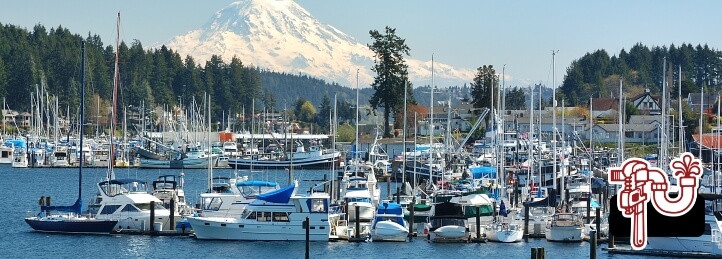Bainbridge Island, WA, the waterfront area with boats on the water, docked boats, and treeline in the background